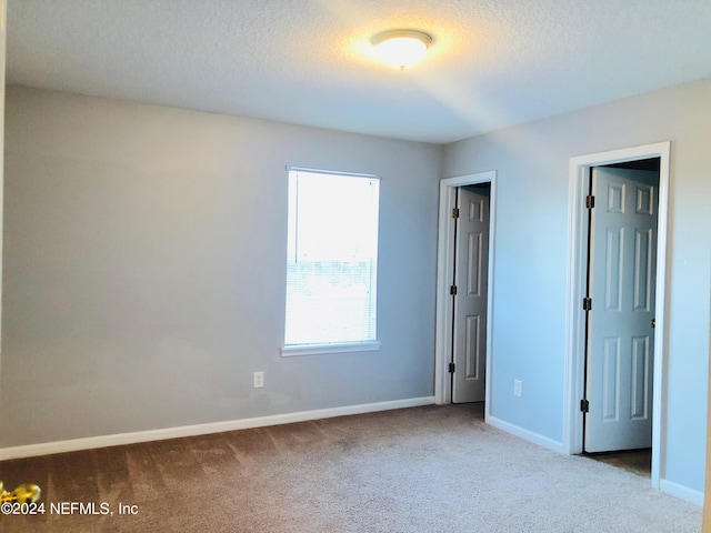 carpeted spare room with a textured ceiling