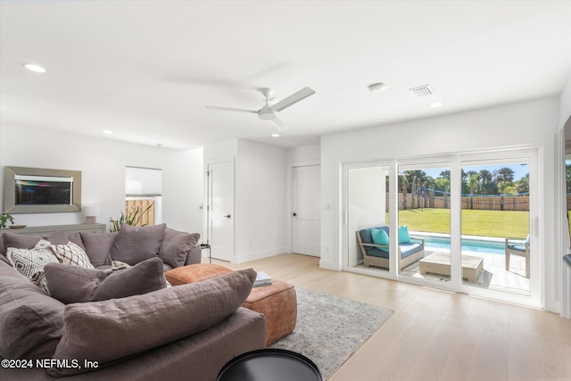 living room with light hardwood / wood-style floors and ceiling fan