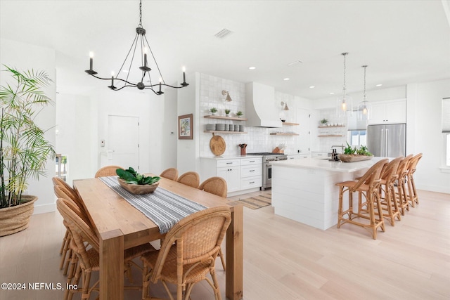 dining area featuring light hardwood / wood-style floors and a notable chandelier