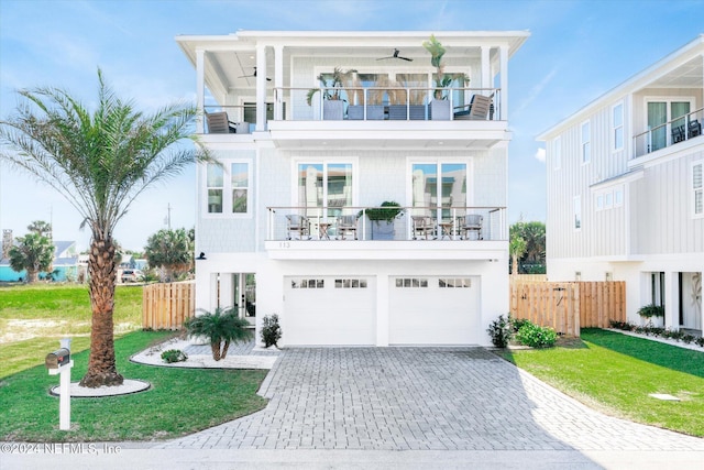 view of front of house with cooling unit, a balcony, a front lawn, and a garage