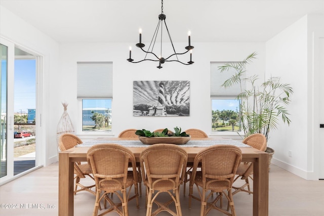 dining room with a notable chandelier, a wealth of natural light, and light hardwood / wood-style flooring