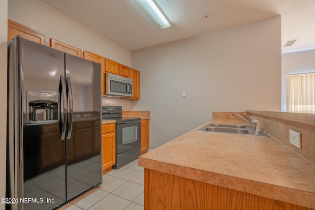 kitchen with a textured ceiling, light tile patterned flooring, sink, and stainless steel appliances