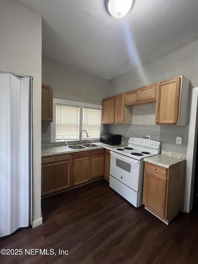 kitchen featuring white electric stove, light countertops, dark wood-type flooring, a sink, and black microwave