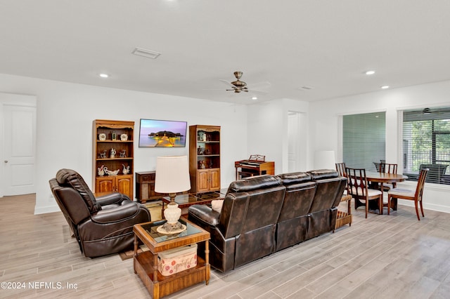 living room featuring light hardwood / wood-style flooring and ceiling fan