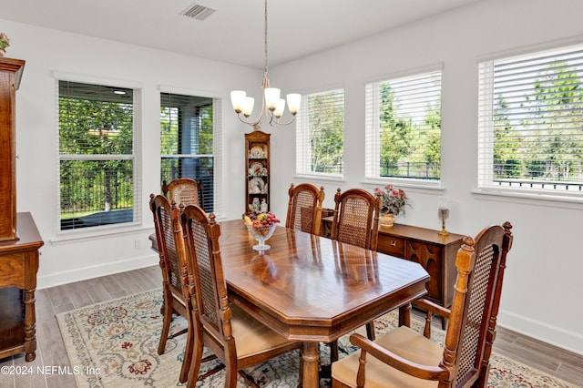 dining area featuring wood-type flooring and an inviting chandelier