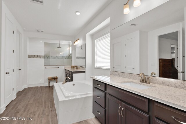 bathroom featuring vanity, wood-type flooring, and shower with separate bathtub