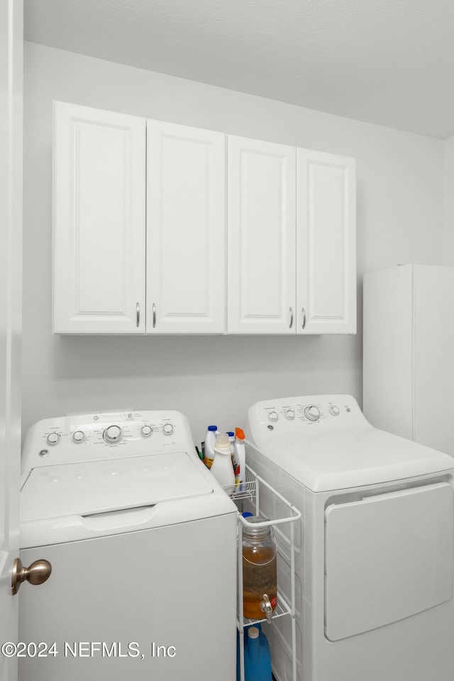 washroom featuring washer and dryer and cabinets