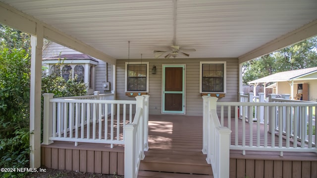 wooden terrace with ceiling fan and covered porch