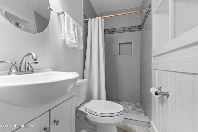 bathroom with a shower with shower curtain, vanity, hardwood / wood-style flooring, and toilet