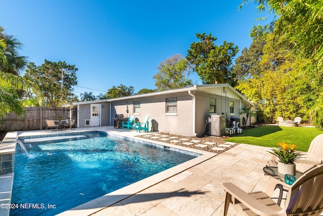 view of pool with pool water feature, a yard, and a patio