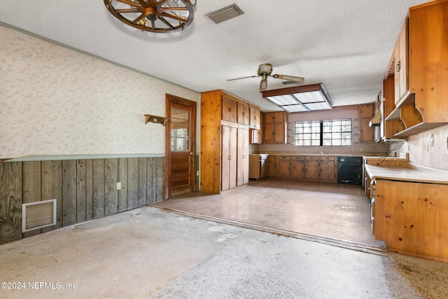 kitchen with wooden walls, ceiling fan, and a textured ceiling