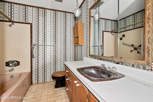 full bathroom with vanity, toilet, a textured ceiling, and tiled shower / bath