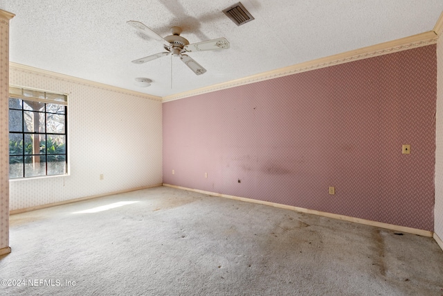 empty room featuring ceiling fan, carpet floors, a textured ceiling, and ornamental molding