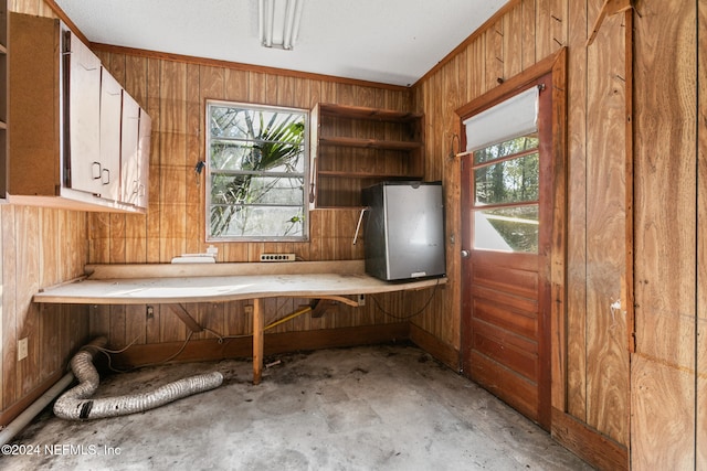 interior space featuring ornamental molding and wooden walls