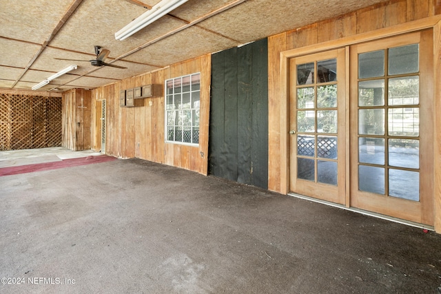 interior space featuring wooden walls, carpet floors, and ceiling fan