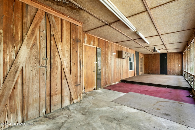 interior space with concrete floors and wood walls