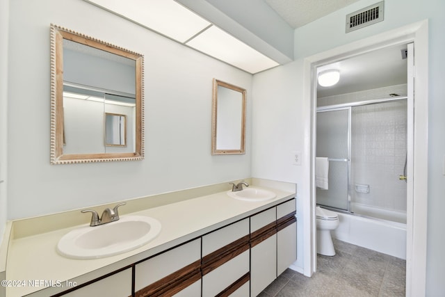 full bathroom with tile patterned floors, vanity, toilet, and enclosed tub / shower combo