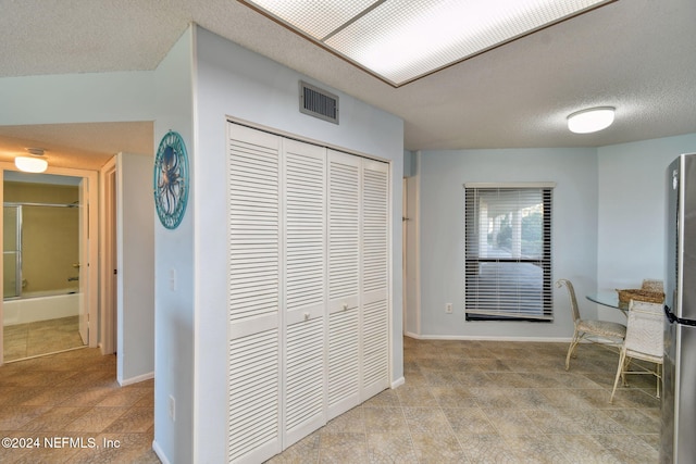 hall featuring a textured ceiling