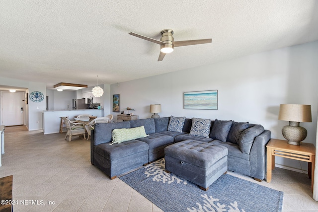 living room with ceiling fan and a textured ceiling