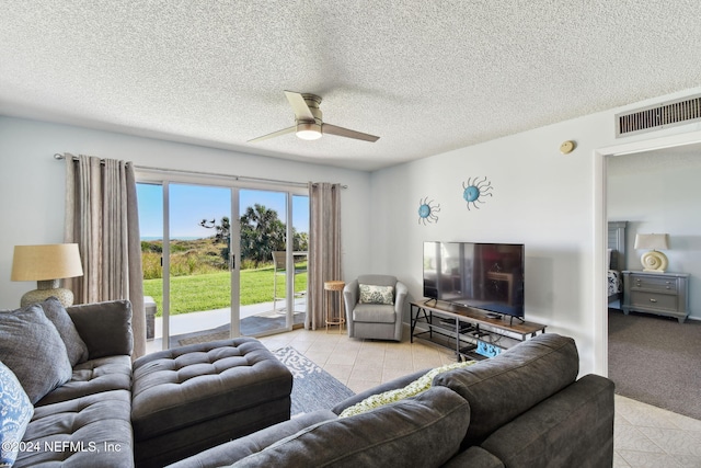 living room featuring ceiling fan and a textured ceiling