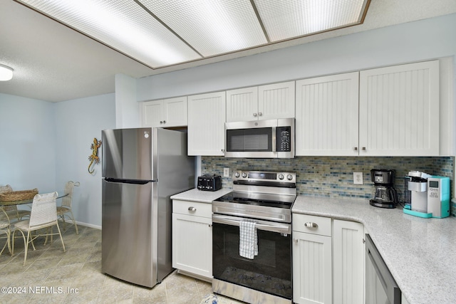 kitchen featuring tasteful backsplash, white cabinets, and stainless steel appliances