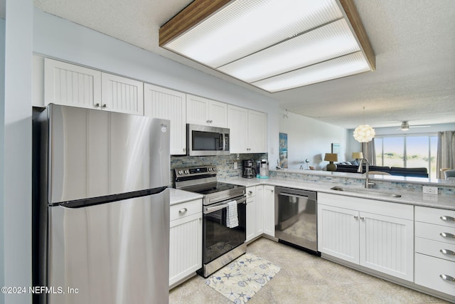 kitchen with white cabinetry, sink, ceiling fan, backsplash, and appliances with stainless steel finishes