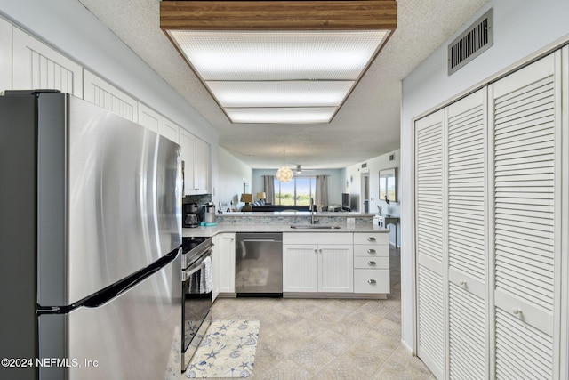 kitchen featuring kitchen peninsula, sink, white cabinets, and appliances with stainless steel finishes