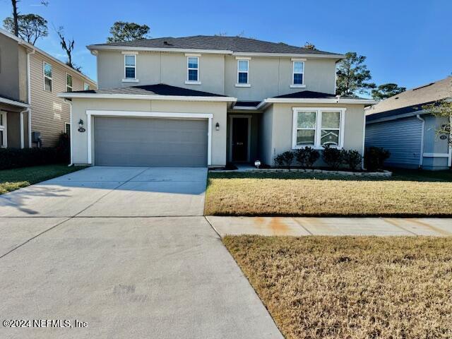 front of property featuring a front yard and a garage