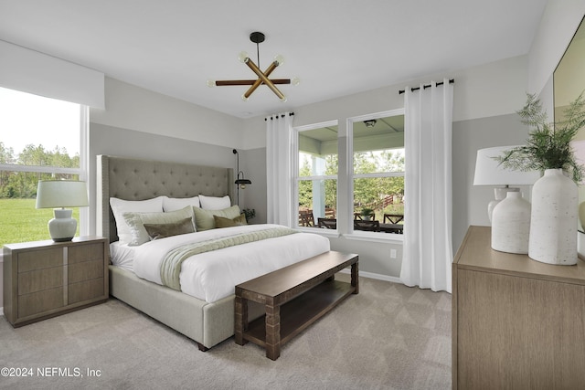 bedroom with light carpet and a chandelier