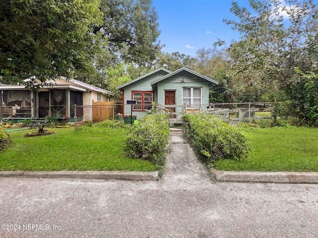 view of front of home with a sunroom and a front yard