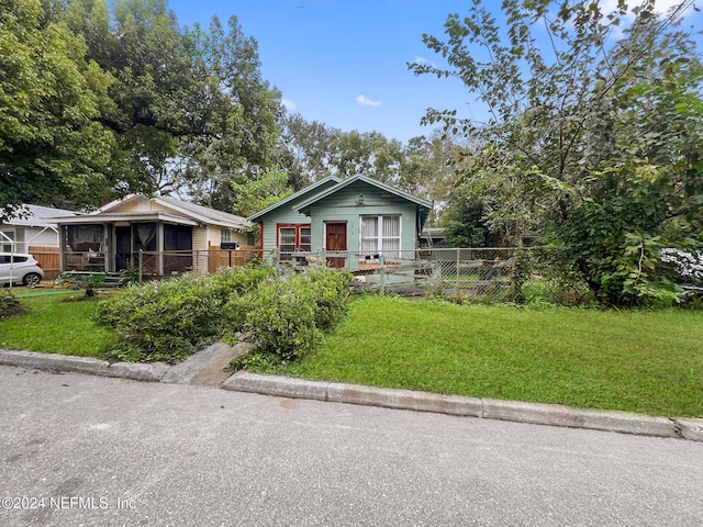 view of front of property with a front yard and a sunroom