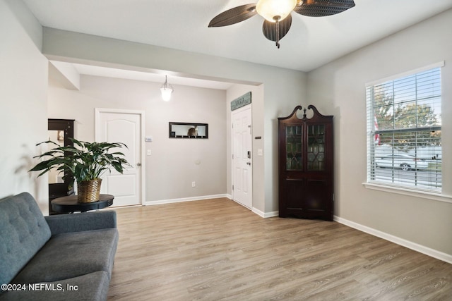 living area with wood-type flooring and ceiling fan