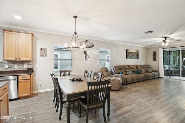 dining space featuring ceiling fan with notable chandelier, light hardwood / wood-style floors, ornamental molding, and a wealth of natural light