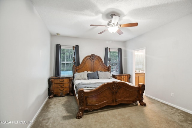 bedroom featuring ensuite bathroom, ceiling fan, light carpet, and a textured ceiling