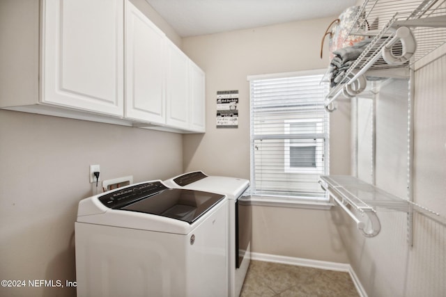 washroom with washing machine and dryer and cabinets