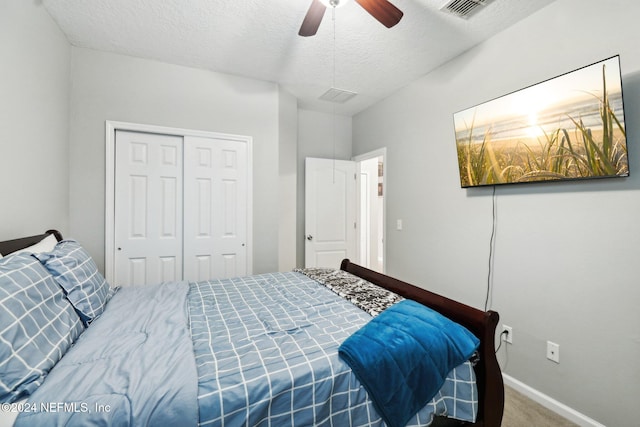 carpeted bedroom with ceiling fan, a textured ceiling, and a closet