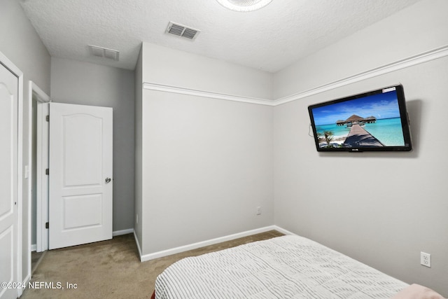 carpeted bedroom with a textured ceiling