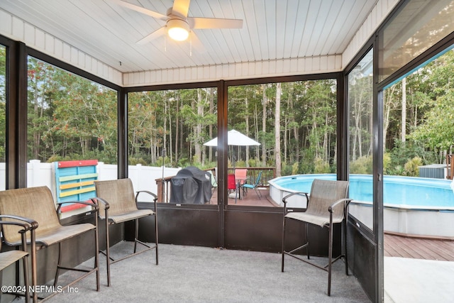 sunroom with ceiling fan and wood ceiling