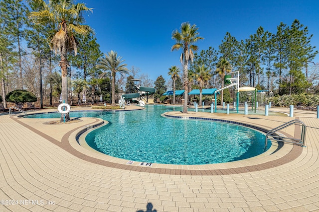 view of pool featuring a patio and a water slide