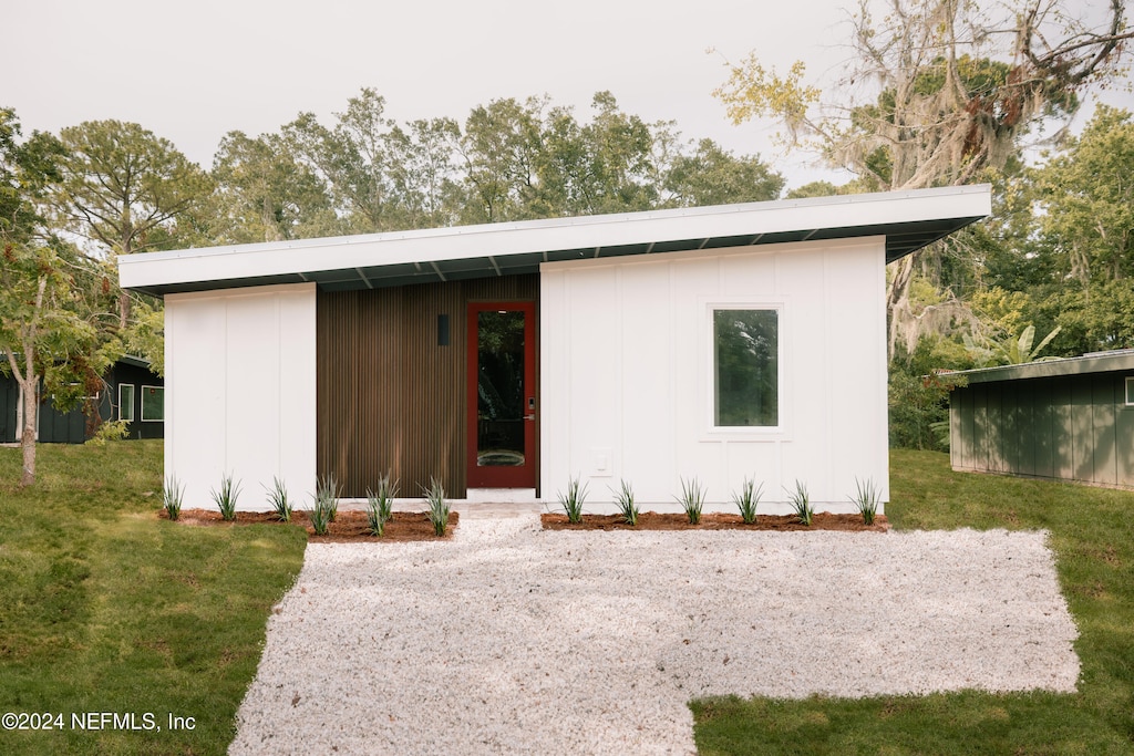 view of front of house with a front yard and a storage unit