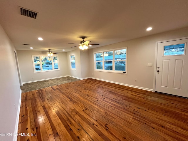 unfurnished living room with dark hardwood / wood-style floors and ceiling fan