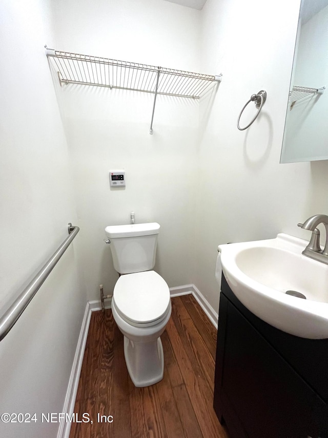 bathroom with vanity, wood-type flooring, and toilet