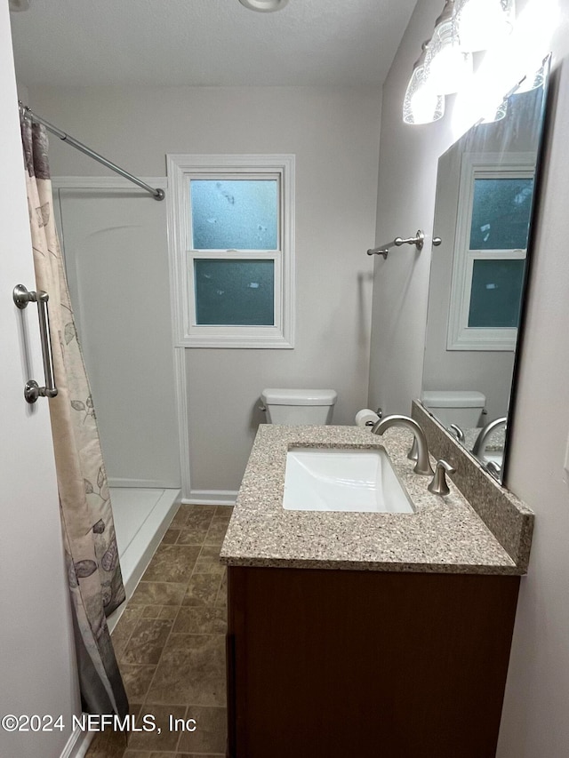 bathroom featuring vanity, curtained shower, and toilet