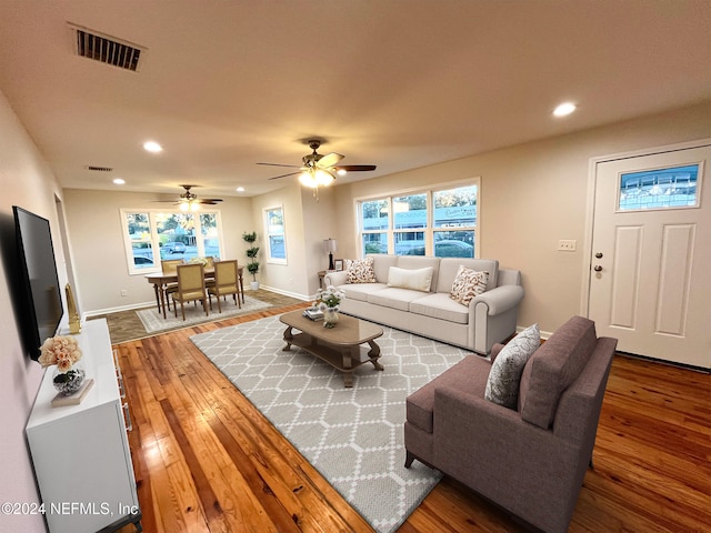 living room featuring ceiling fan and hardwood / wood-style flooring