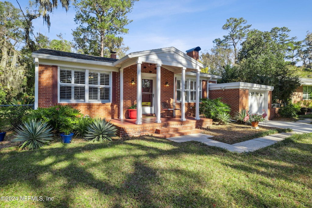 view of front of home with a front yard and a garage