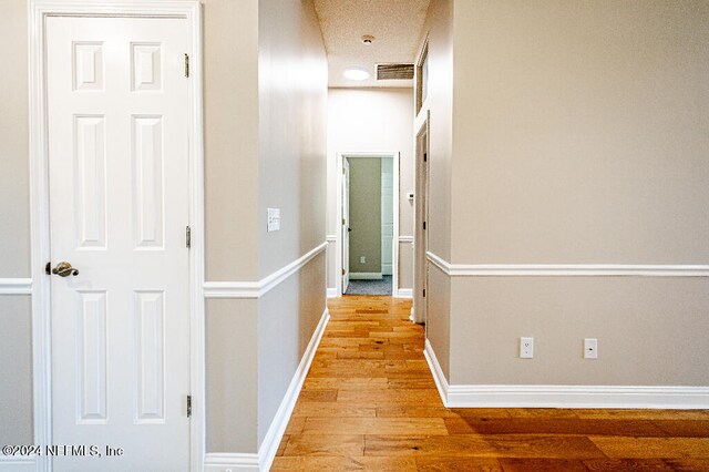 hallway featuring a textured ceiling and light wood-type flooring