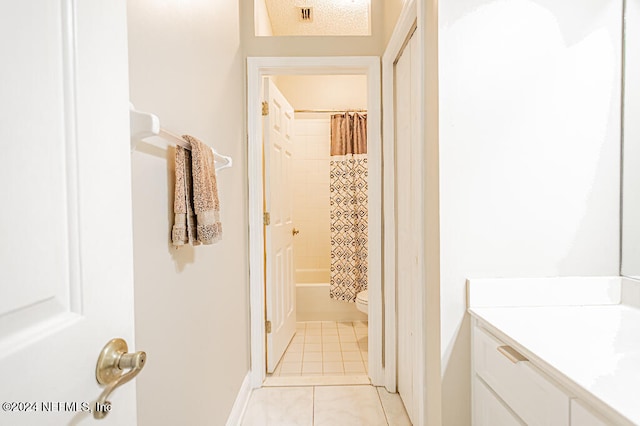 full bathroom featuring tile patterned flooring, shower / bath combo, toilet, and vanity