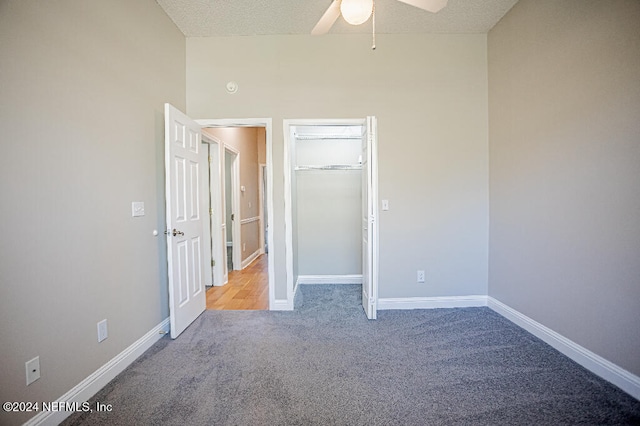 unfurnished bedroom with ceiling fan, a closet, light colored carpet, and a textured ceiling