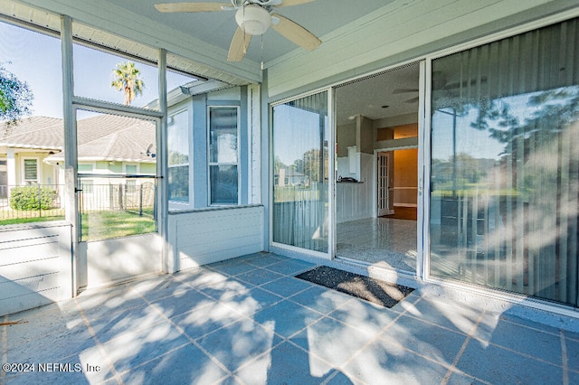 unfurnished sunroom with ceiling fan