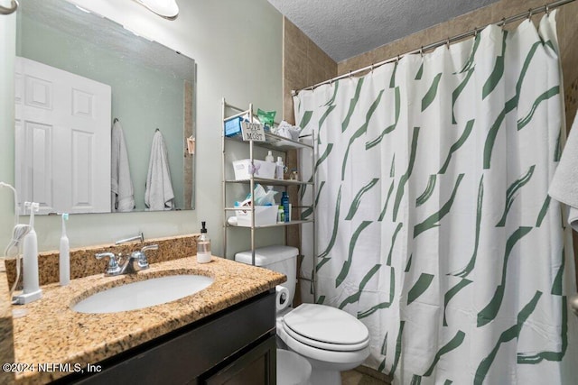 bathroom with a shower with curtain, vanity, toilet, and a textured ceiling